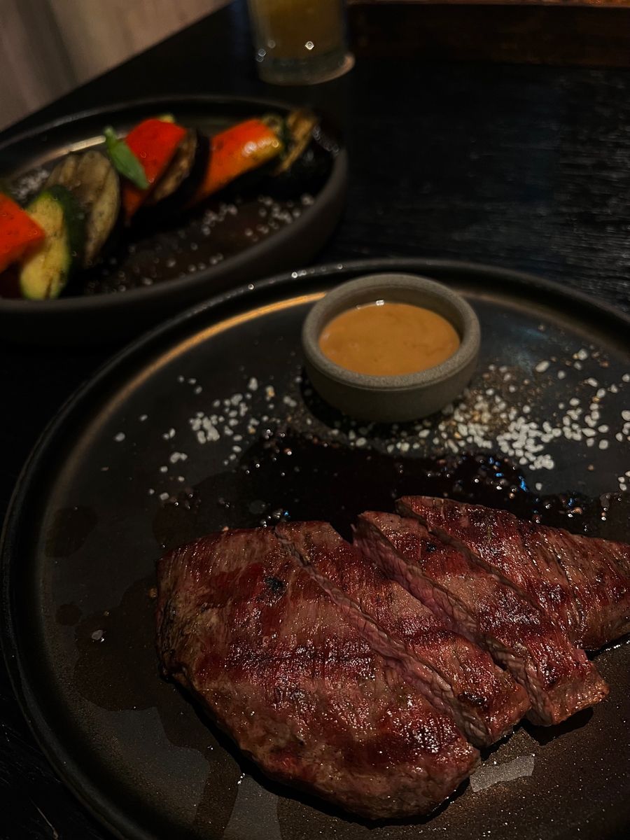 Danie fine dining: mięso z sosem i ziołami na ciemnym talerzu